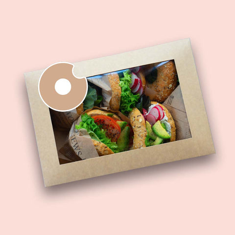 Verschiedene Bagel-Boxen mit 10 frisch belegten Bagels, garniert mit Frischkäse, Lachs, Avocado, Gemüse und Kräutern