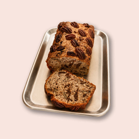 Veganes Bananenbrot von Adeli mit Schoko und Pekannüssen, aufgeschnitten auf einem Backblech, ca. 30 cm
