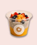 Veganer Chia Cup von Adeli mit Mangopüree, Kokosjoghurt-Chiapudding und frischen Früchten wie Erdbeeren, Blaubeeren und Mango