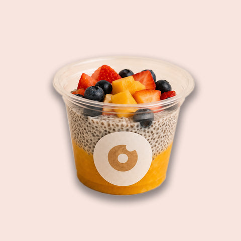 Veganer Chia Cup von Adeli mit Mangopüree, Kokosjoghurt-Chiapudding und frischen Früchten wie Erdbeeren, Blaubeeren und Mango
