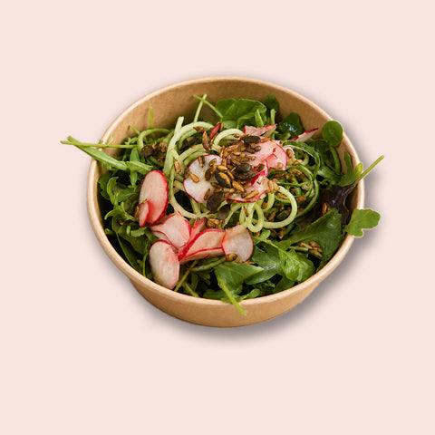 Veganer gemischter Salat von Adeli mit Gurkennudeln, Radieschen und gerösteten Kernen in einer Schüssel